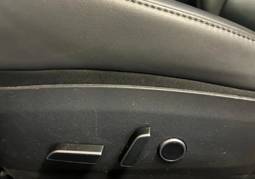 Gros plan sur les commandes de réglage électrique du siège avant d’une Tesla Model 3 blanche, version 2023.