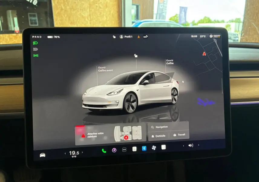 Écran tactile intérieur montrant une Tesla Model 3 blanc en vue 3/4 avant avec options d'ouverture des coffres.