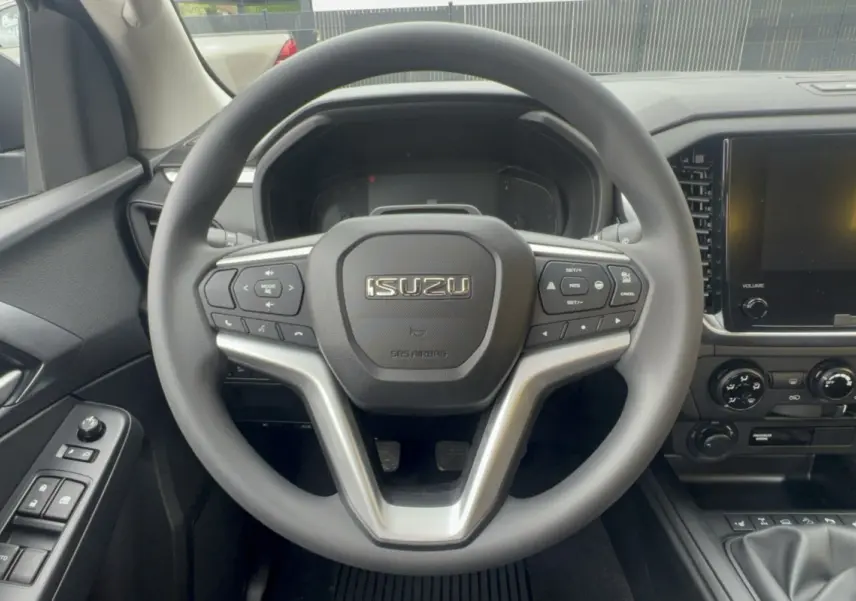 Vue centrée sur le volant multifonctions noir de l'Isuzu D-MAX 2026 avec tableau de bord et écran tactile.