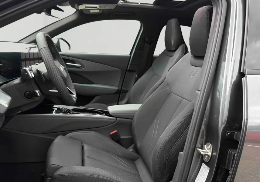 Vue intérieure côté conducteur de l'Audi Q3 Sportback gris, sièges sport avec logo S et toit ouvrant panoramique visible.