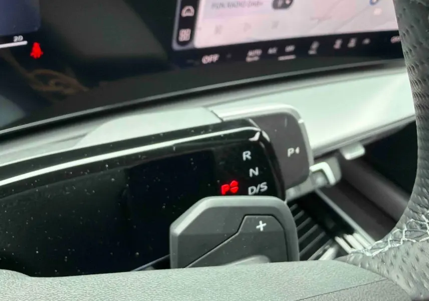 Gros plan sur la commande de boîte manuelle et palettes au volant de l'Audi Q3 Sportback gris, intérieur moderne.