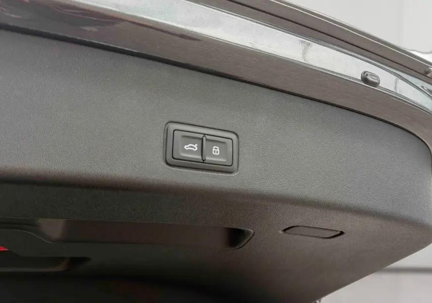 Gros plan sur la partie intérieure du hayon arrière gris de l'Audi Q3 Sportback avec boutons d'ouverture et verrouillage.