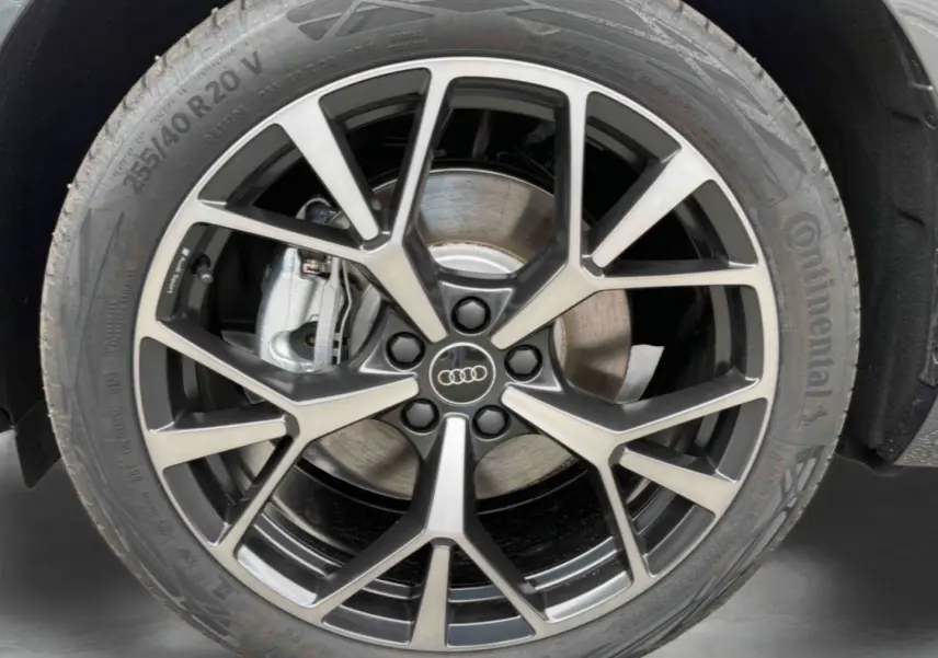 Gros plan sur la jante Audi Sport tripode noire et métal brossé de 20 pouces du Q3 Sportback gris.