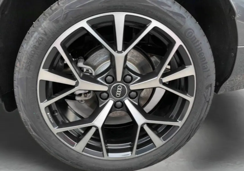 Gros plan sur la jante Audi Sport tripode noire et argentée du Q3 Sportback gris, avec pneu Continental 255/40 R20.