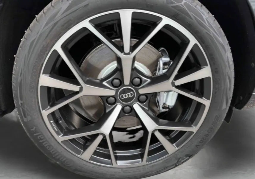 Gros plan sur la jante Audi Sport tripode noire métallisée 5 branches du Q3 Sportback gris avec frein visible.