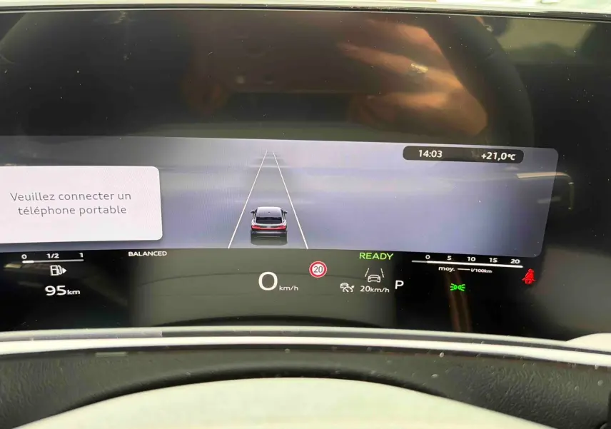 Vue rapprochée du combiné d'instruments numérique OLED de l'Audi Q3 Sportback gris affichant la vitesse et l'alerte de connexion téléphone.