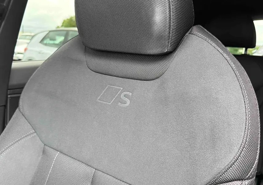 Gros plan sur le siège avant conducteur gris avec logo S embossé, intérieur Audi Q3 Sportback 2026.