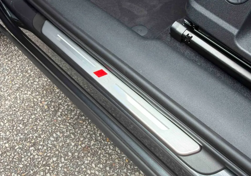 Seuil de porte avant gauche gris métallisé avec logo S sur Audi Q3 Sportback 2026, intérieur noir.