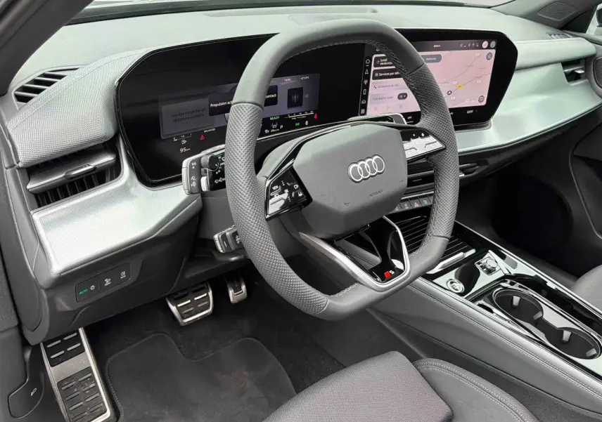 Vue intérieure côté conducteur de l'Audi Q3 Sportback gris, volant sport multifonctions et tableau de bord numérique OLED.