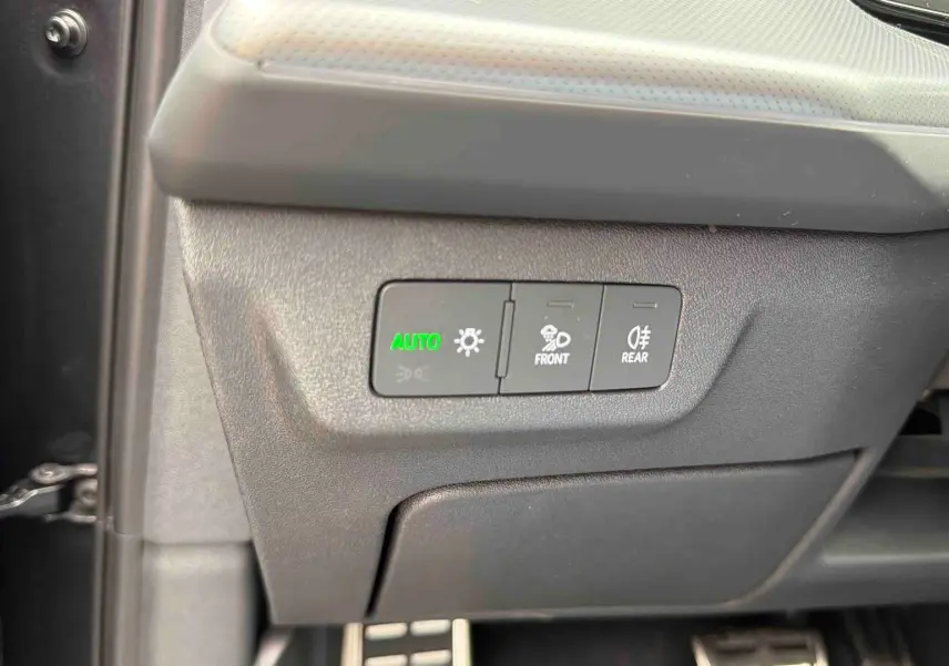 Gros plan sur les commandes d’éclairage avec bouton auto allumé dans l’habitacle de l’Audi Q3 Sportback gris.