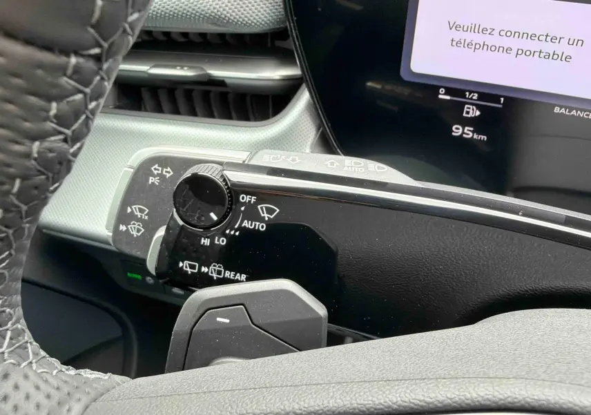 Gros plan sur la commande des essuie-glaces et le combiné numérique de l'Audi Q3 Sportback gris, intérieur moderne.