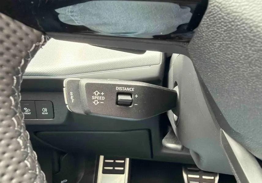 Gros plan sur la commande de régulateur de vitesse et la pédale en acier dans l’habitacle de l’Audi Q3 Sportback gris.