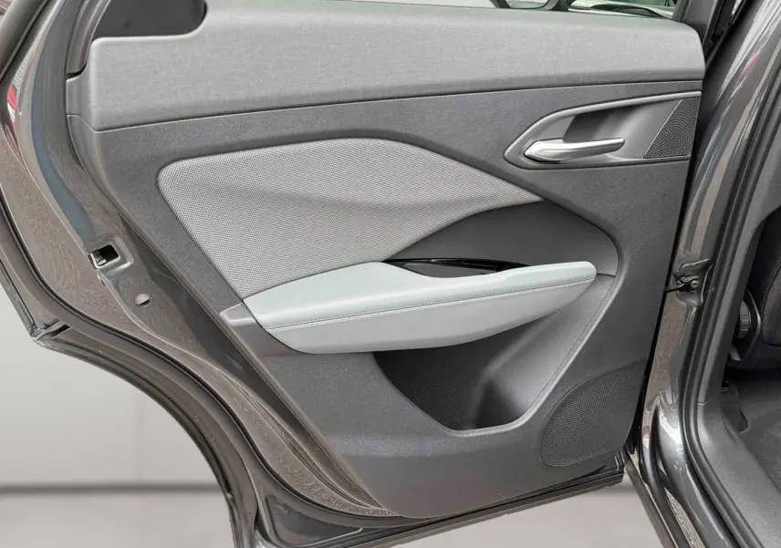 Vue rapprochée de la porte arrière gauche grise de l’Audi Q3 Sportback avec garniture tissu et accoudoir clair.