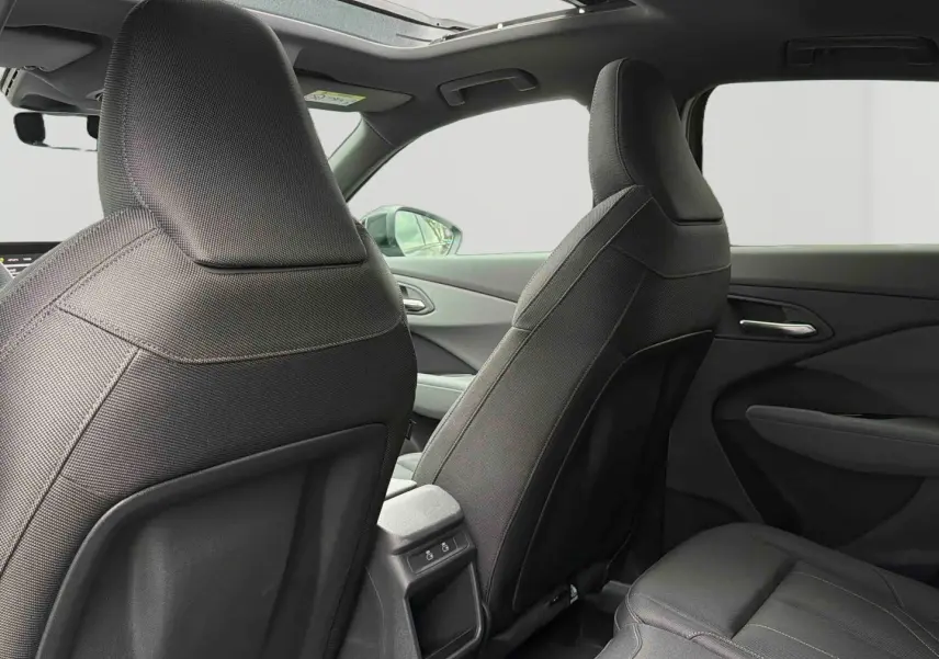 Vue intérieure arrière de l’Audi Q3 Sportback gris, montrant les sièges avant et le toit ouvrant panoramique.