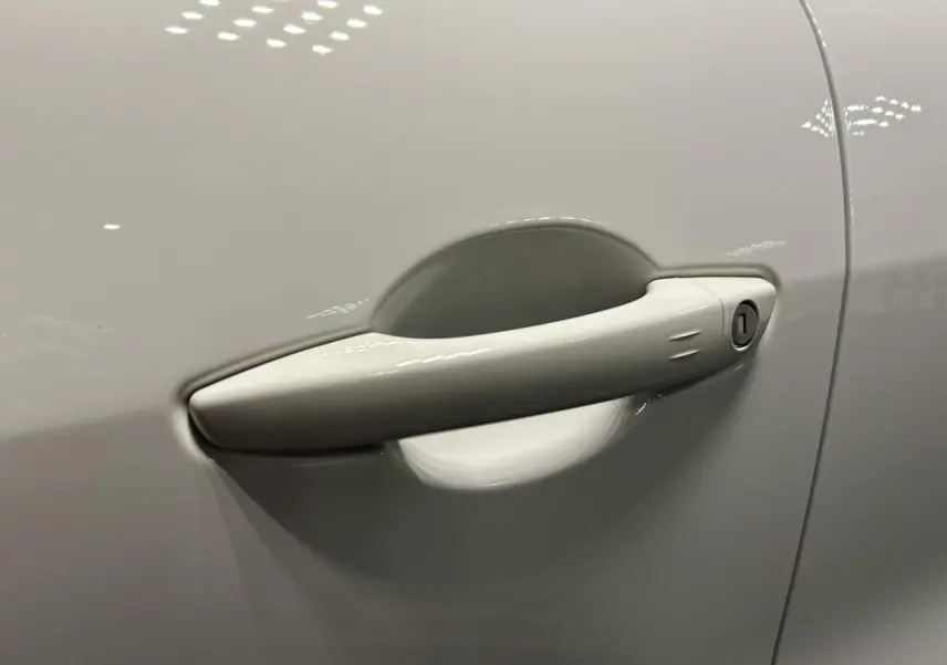 Poignée de porte blanche en gros plan sur le côté gauche d'une FIAT 600 hybride 2026.