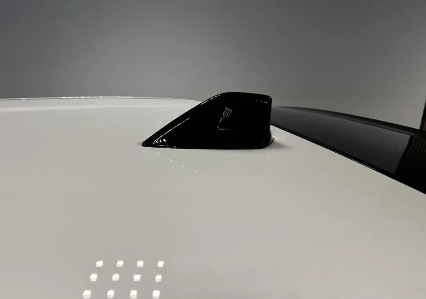 Détail de l'antenne requin noire sur le toit blanc d'une Fiat 600 hybride 2026, vue de dessus rapprochée.