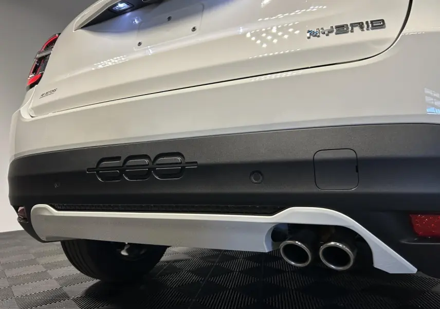 Vue rapprochée arrière droite de la FIAT 600 blanche avec logo Hybrid et double sortie d’échappement chromée.