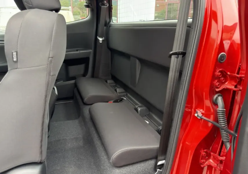 Vue intérieure côté droit des sièges arrière strapontins du pick-up Isuzu D-MAX 2.2 TD 164 Space Evolution orange Namibu.