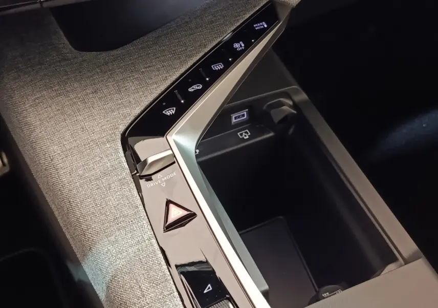 Vue rapprochée de la console centrale du Peugeot 5008 gris clair, avec commandes tactiles et rangement intégré.