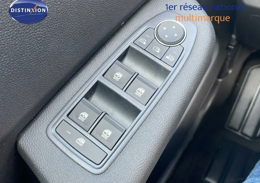 Gros plan sur les commandes des vitres électriques côté conducteur d'une Renault Clio gris schiste métal 2025.