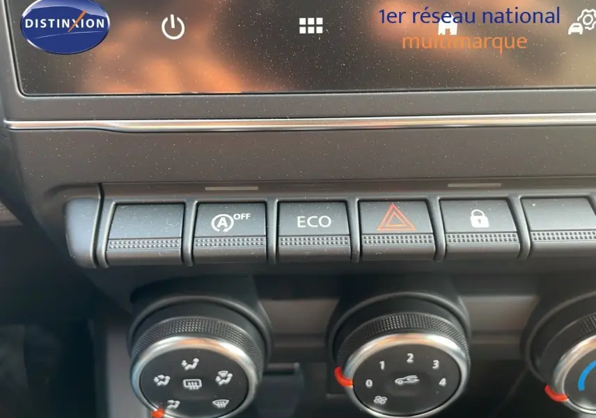 Gros plan sur la console centrale de la Renault Clio gris schiste, montrant les boutons de commande et les réglages climatiques.