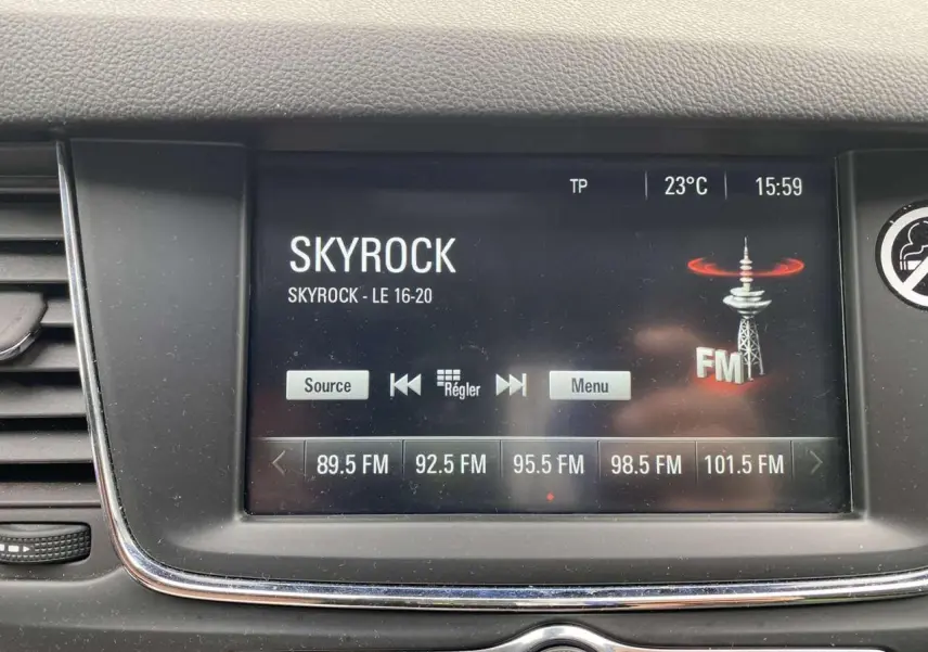 Écran tactile multimédia de l’Opel Astra 1.2i Turbo Edition 2021 affichant la radio Skyrock en intérieur noir.