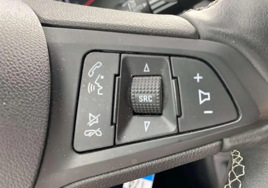 Gros plan sur les commandes audio et téléphone intégrées au volant noir de l’Opel Astra Sovereign Silver 2021.