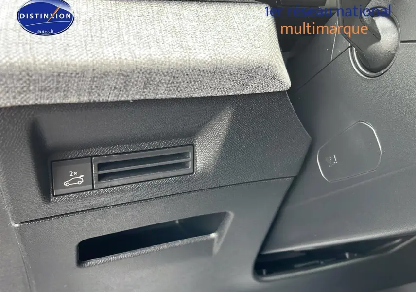 Détail du tableau de bord côté gauche du Peugeot 3008 gris, montrant la commande d'ouverture du coffre et la finition tissu.