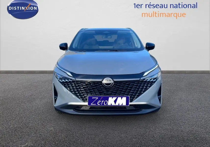 Vue avant d'un Nissan Qashqai 2025 gris argile métal avec calandre noire et phares LED fins.