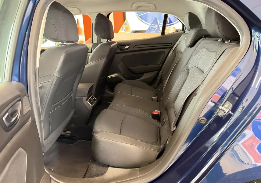 Vue intérieure côté gauche montrant la banquette arrière noire d'une Renault Mégane bleu 2019, portes ouvertes.