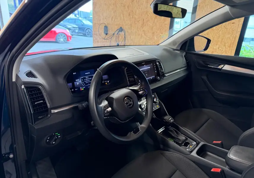 Vue intérieure côté conducteur du Skoda Karoq 2.0 TDI bleu, volant multifonctions et tableau de bord numérique.