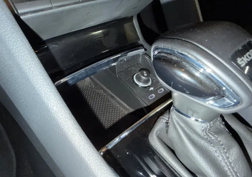 Gros plan sur le levier de vitesses automatique noir avec surpiqûres grises dans la console centrale du Skoda Karoq.