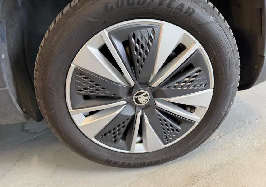 Gros plan sur la jante alu 17 pouces bicolore et pneu Goodyear d’un Skoda Karoq bleu 2023 côté droit.
