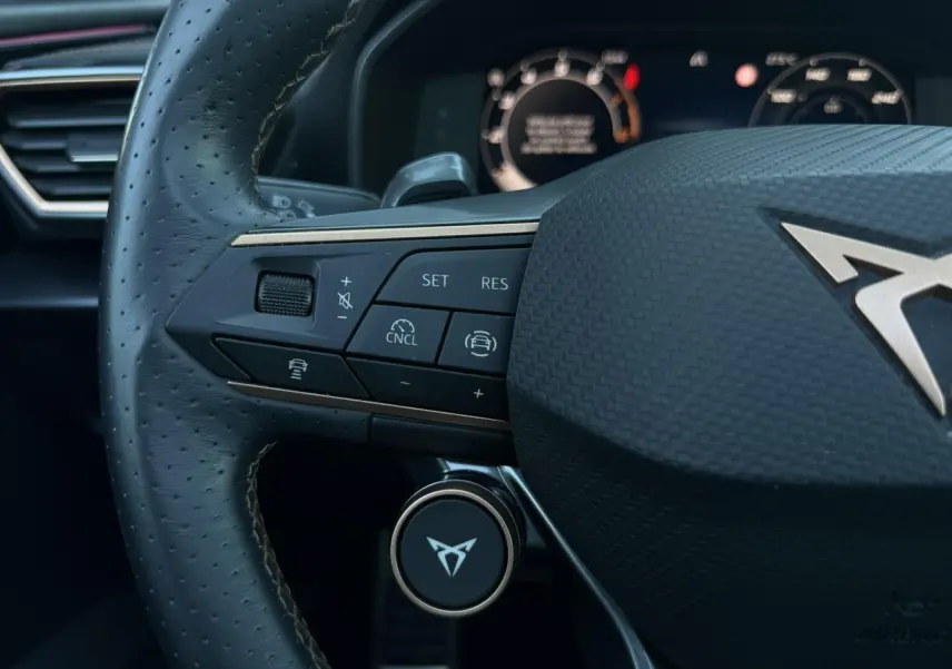 Gros plan sur le volant cuir perforé noir de la CUPRA Formentor 2025 avec commandes multifonctions et logo CUPRA central.