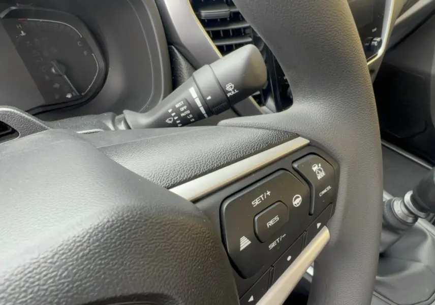 Gros plan sur le volant multifonctions noir de l'Isuzu D-MAX 2026 avec commandes de régulateur et aide à la conduite.