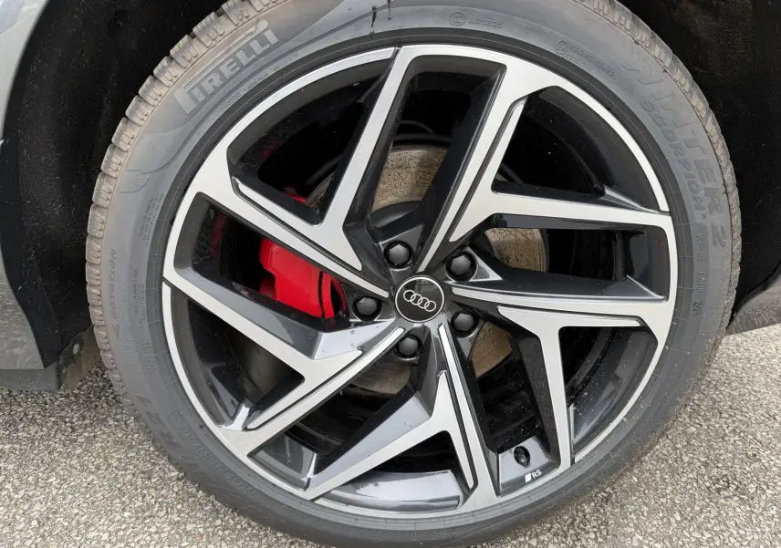 Gros plan sur la jante Audi Sport noire et argentée avec étrier de frein rouge du Q6 e-tron gris nacré.