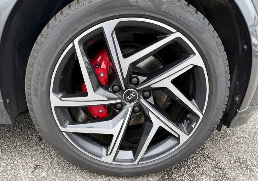 Gros plan sur la jante Audi Sport noire et argentée avec étrier de frein rouge du Q6 e-tron gris nacré.