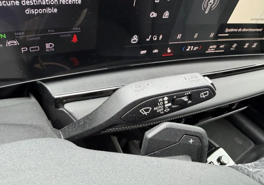 Gros plan sur la commande des essuie-glaces et palettes au volant de l’Audi Q6 e-tron 2024 avec tableau de bord numérique.