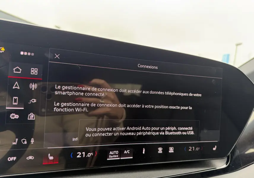 Vue intérieure du tableau de bord de l'Audi Q6 e-tron gris, écran tactile affichant les options de connexion smartphone.