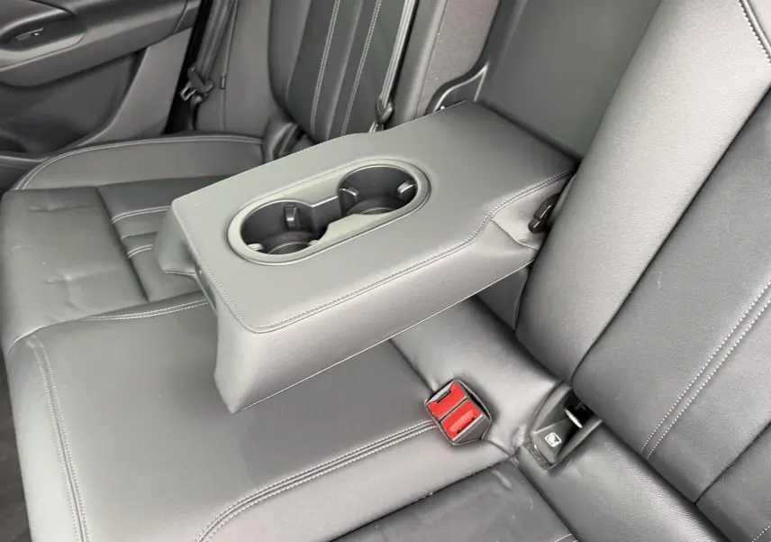 Vue rapprochée de la banquette arrière en cuir noir avec accoudoir central et porte-gobelets de l'Audi Q6 e-tron 2024.