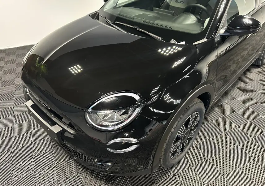 Vue 3/4 avant droite d'une FIAT 600 noire avec phares LED ronds et jantes alliage noires au design complexe.