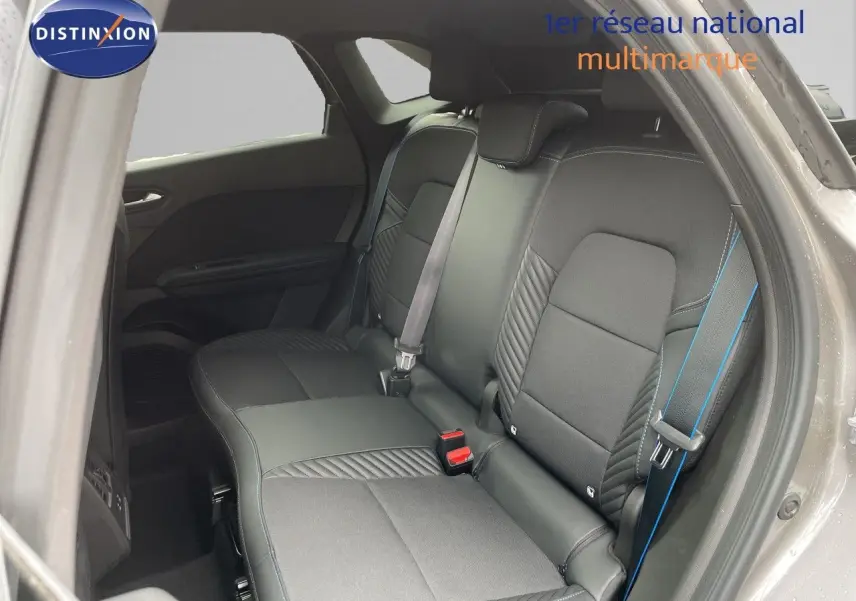 Vue intérieure sur la banquette arrière de la Renault Symbioz 2026 gris Cassiopée Métal avec surpiqûres bleues et ceintures assorties.