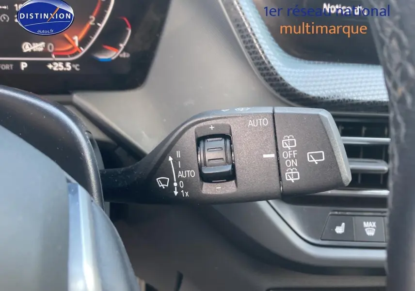 Gros plan sur la commande des essuie-glaces à gauche du volant d'une BMW Série 1 gris foncé 2023 édition sport.