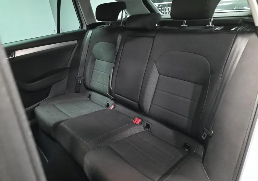 Vue intérieure montrant la banquette arrière noire avec appuie-têtes réglables d'une Skoda Superb Combi blanche.