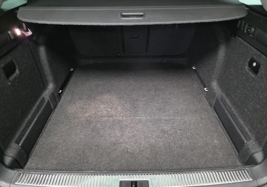 Coffre spacieux de break SKODA SUPERB Combi 2018 vu de l'arrière, intérieur noir avec tapis et éclairage.