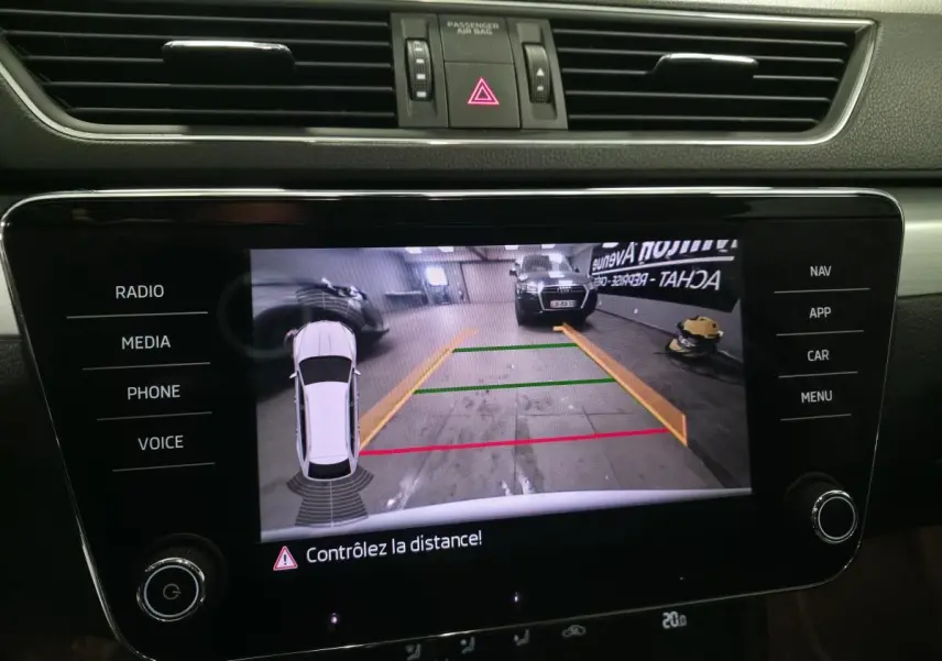 Affichage de la caméra de recul sur l'écran central du Skoda Superb Combi blanc, vue intérieure du tableau de bord.