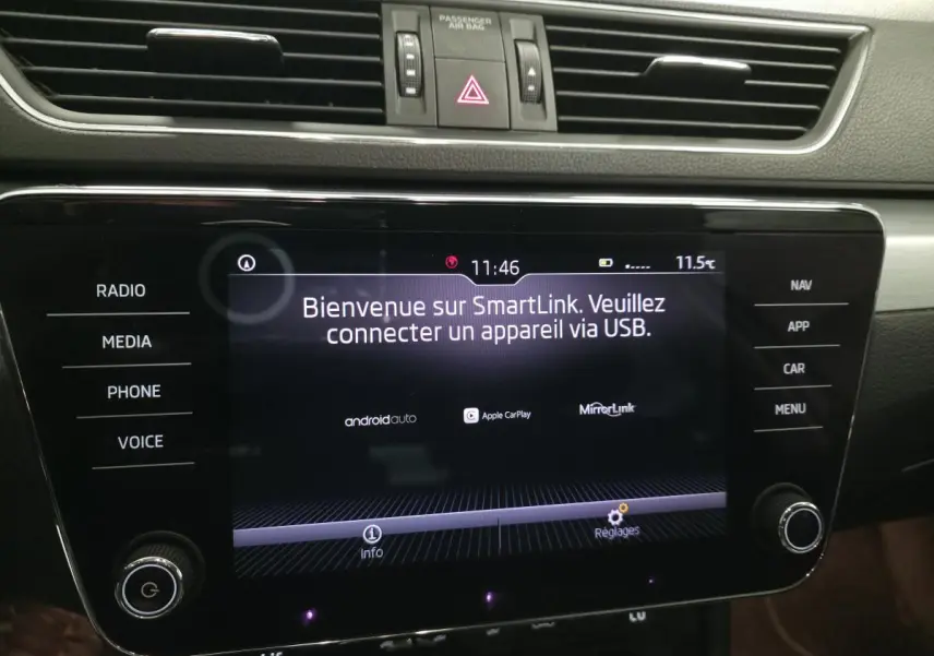 Écran tactile central du tableau de bord de la Skoda Superb Combi blanc, affichant SmartLink et commandes autour.