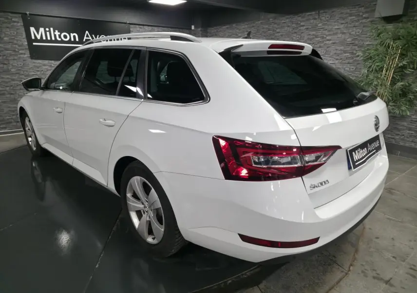 Vue 3/4 arrière droite d'un break SKODA SUPERB blanc avec feux arrière LED et jantes alliage 17 pouces.
