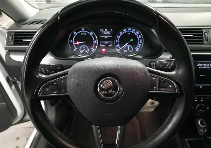 Volant noir multifonctions SKODA Superb 2018 vu de face avec tableau de bord et compteurs éclairés.