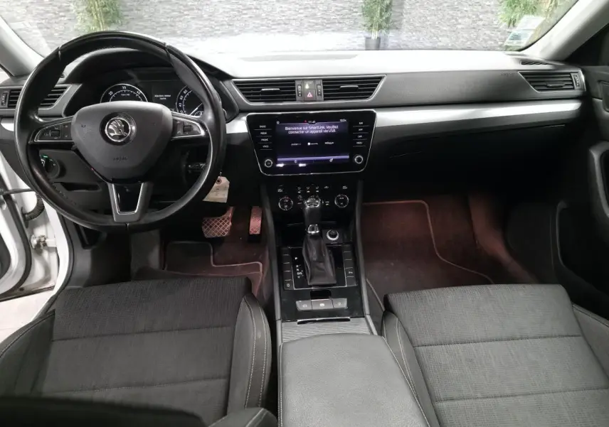 Intérieur noir de la Skoda Superb Combi 2018 vu de face, avec tableau de bord moderne et écran tactile central.